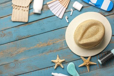 Farklı plaj aksesuarları, kulaklıklar ve ahşap arka planda saç fırçaları olan kompozisyon