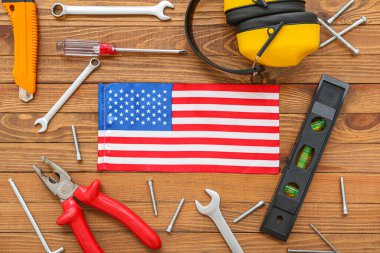 Farklı aletler ve ahşap arka planda ABD bayrağı olan kompozisyon. İşçi Bayramı kutlamaları
