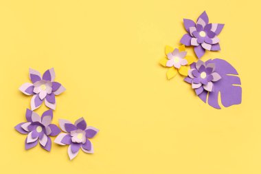 Renkli origami çiçekleri ve sarı arkaplanda yapraklar