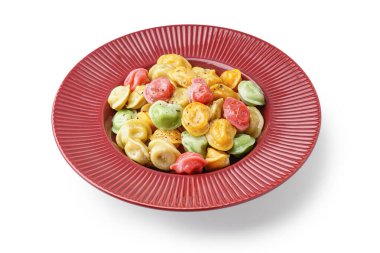 Beyaz arka planda kaynamış renkli hamur tatlısı tabağı