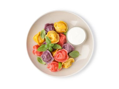 Beyaz arka planda fesleğenli ve ekşi kremalı kaynamış hamur köftesi tabağı.