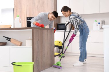 Mutfakta temizlik yapan mutlu genç çift.