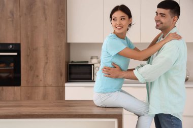 mutlu genç bir çift mutfakta sarılma