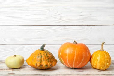 Beyaz ahşap arka planda farklı taze balkabakları