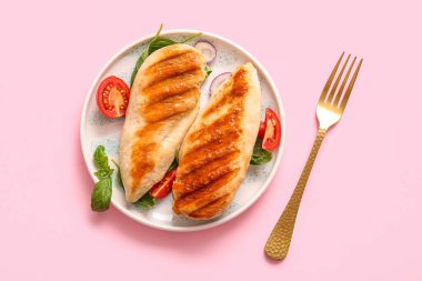 Lezzetli ızgara tavuk göğsü fesleğen, domates ve pembe arka planda kırmızı soğan.