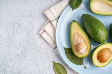 Beyaz arka planda taze olgun avokadolarla kaplanmış.