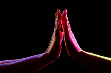 Karanlık arka planda ellere dokunan kadın silueti, yakın plan.