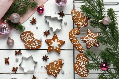 Yıldız anasonlu Noel kurabiyeleri, köknar dalları ve beyaz ahşap arka planda toplar.