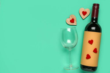Turkuaz arka planda Sevgililer Günü için şarap ve cam karışımı.