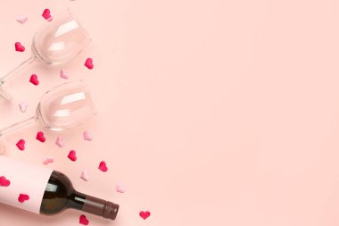 Pembe arka planda Sevgililer Günü için şarap ve gözlüklü kompozisyon