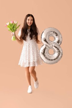 Gümüş renkli hava balonu olan güzel bir Asyalı kadın figür 8 ve kahverengi arka planda bir buket güzel lale. Uluslararası Kadınlar Günü