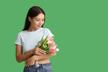 Yeşil arka planda güzel lalelerle dolu bir buket güzel Asyalı kadın. Uluslararası Kadınlar Günü