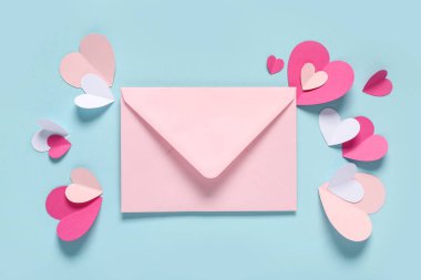 Pembe zarflı kompozisyon ve renkli arka planda kağıt kalpler. Sevgililer Günü kutlaması