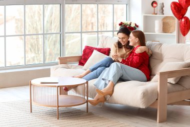 Young lesbian couple hugging at home on Valentine's Day