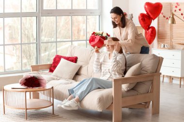 Genç lezbiyen kadın sevgilisini sevgililer gününde hediyeyle karşılıyor.