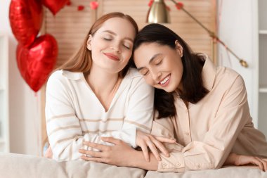Young lesbian couple hugging at home on Valentine's Day
