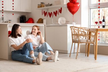 Sevgililer gününde mutfakta oturan genç lezbiyen çift