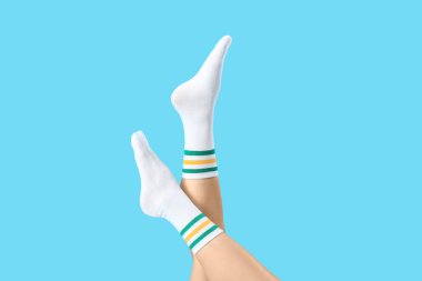 Mavi arka planda beyaz çoraplı kadın.