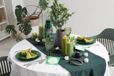 Yemek odasında mumlarla servis edilen şenlik masası, yakın çekim. Aziz Patrick Günü kutlaması