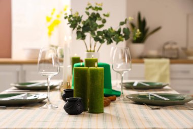 Yemek odasında cüce şapkası ve yanan mumlarla servis edilen şenlik masası. Aziz Patrick Günü kutlaması