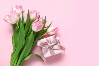 Pembe arka planda laleleri olan hediye kutusu.