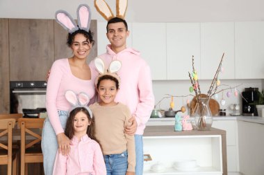 Paskalya günü mutfakta tavşan kulaklı mutlu bir aile.