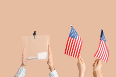 Oy sandığı olan eller ve bej arka planda ABD bayrakları. Seçim kavramı
