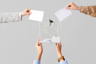 Eller oy pusulasına beyaz arka planda oy veriyor. Seçim kavramı