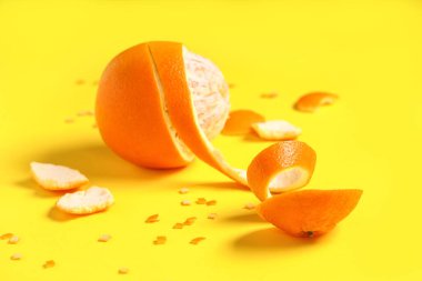 Taze portakallı kompozisyon ve sarı arka planda kabuk.