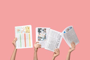 Pembe arka planda gazeteleri olan kadınlar
