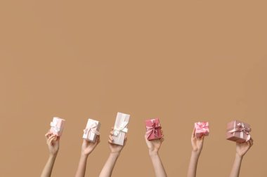 Kahverengi arka planda hediyeleri olan kadınlar. Anneler Günü kutlaması