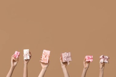 Kahverengi arka planda hediyeleri olan kadınlar. Anneler Günü kutlaması