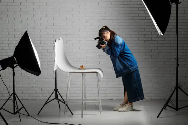 Female food photographer taking picture of pancakes in studio