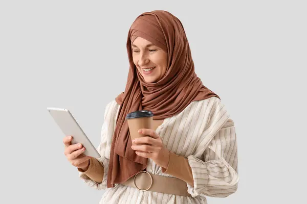 Starší Muslimská Žena Hidžábu Počítačem Tablet Šálek Kávy Světlém Pozadí — Stock fotografie