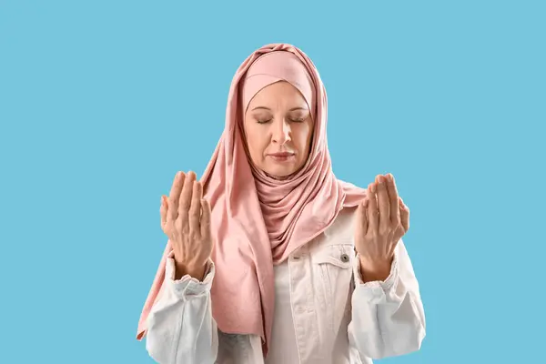 Starší Muslimská Žena Hidžábu Modlí Modrém Pozadí — Stock fotografie