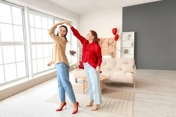 Young lesbian couple dancing at home on Valentine's Day