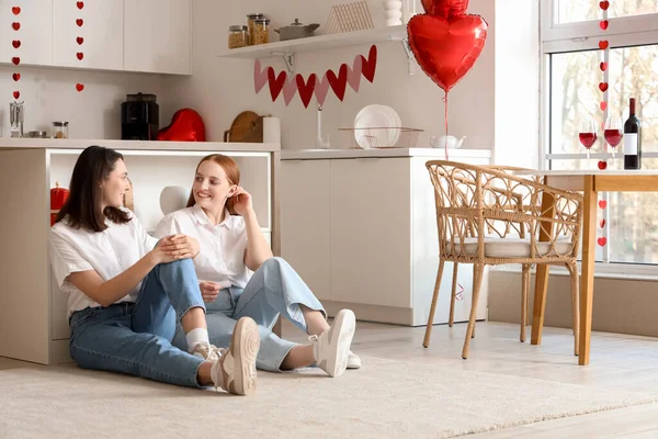 Sevgililer gününde mutfakta oturan genç lezbiyen çift