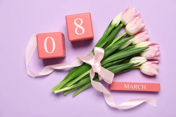 Tulip flowers with ribbon and calendar on purple background. International Women\'s Day celebration
