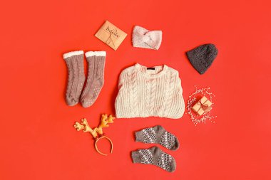 Kırmızı arka planda süslemeleri olan şirin kış çocukları kıyafetleri.