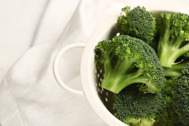 Beyaz arka planda taze brokolili Colander.