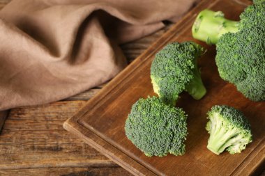 Ahşap zemin üzerinde taze yeşil brokoli olan tahta.