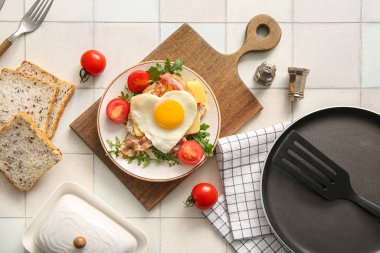 Lezzetli kızarmış yumurta, tost, pastırma, domates ve açık fayanslı roka karışımı.