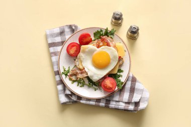 Lezzetli kızarmış yumurta, tost, pastırma, domates ve bej arkaplanlı roka.