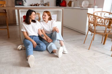 Sevgililer gününde mutfakta oturan genç lezbiyen çift