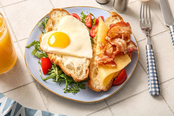 Lezzetli yumurta tabağı, kruvasan, pastırma, domates ve bir bardak meyve suyu.