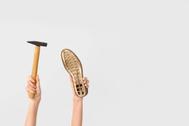 Ayakkabı parçalı kadın eller ve beyaz arka planda çekiç. Ayakkabı tamir konsepti