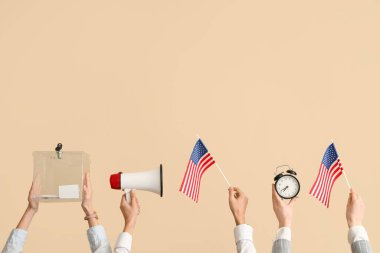 Oy sandığı olan eller, ABD bayrakları, megafon ve bej arka planda çalar saat. Seçim kavramı