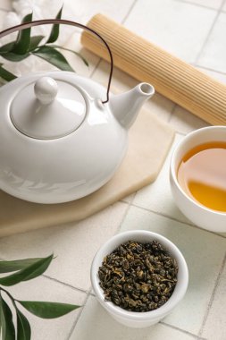 Çaydanlık ve kase, beyaz fayanslı kuru yapraklı, yakın plan.