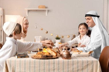 Mutlu Müslüman bir aile evde yemek yiyor. Ramazan kutlaması