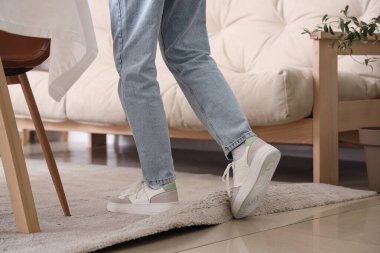 Evde halıya takılıp düşen genç bir kadın. Travma konsepti